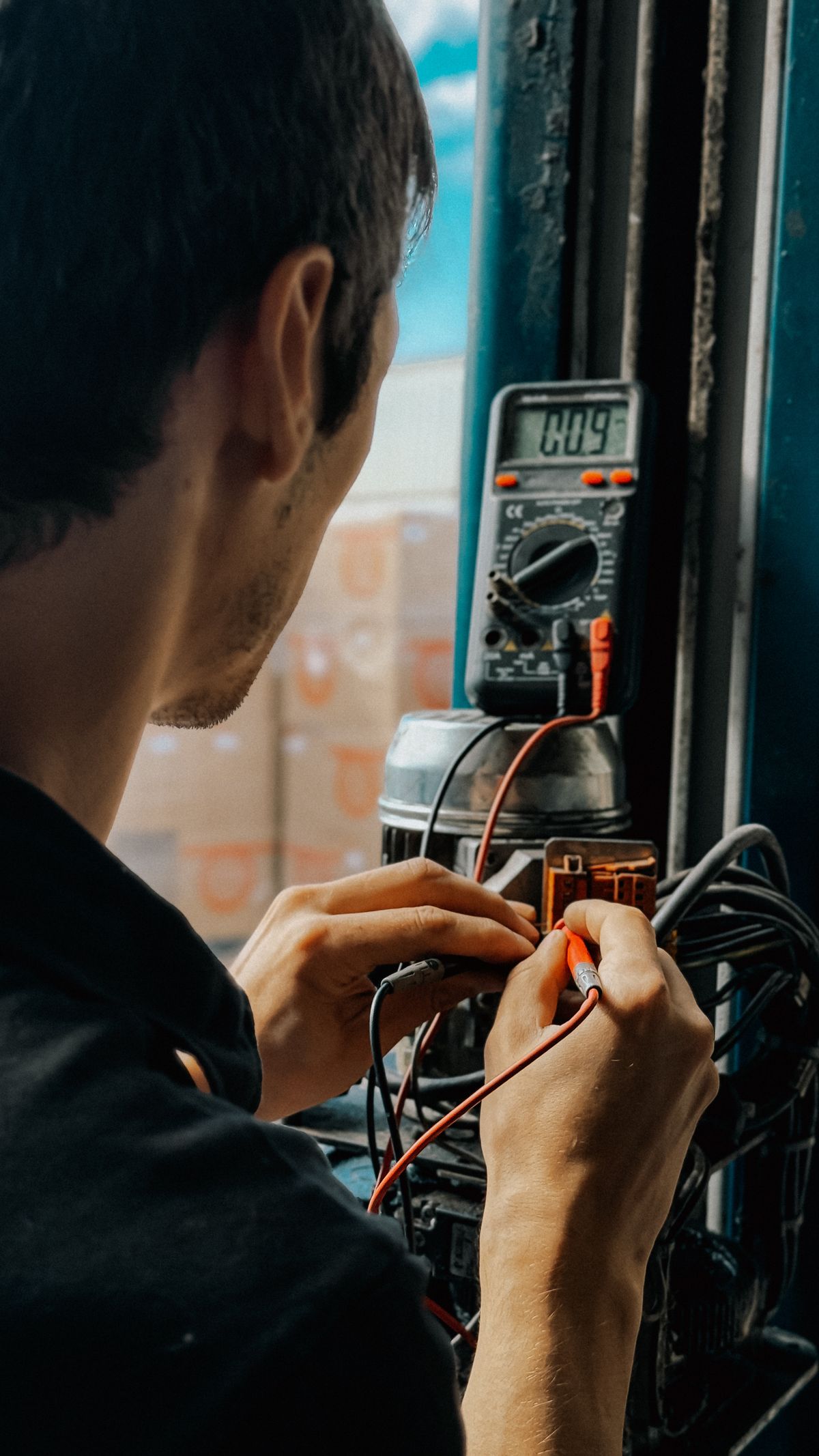 Licensed electrician testing a home electrical panel with a multimeter in Virginia Beach, VA
